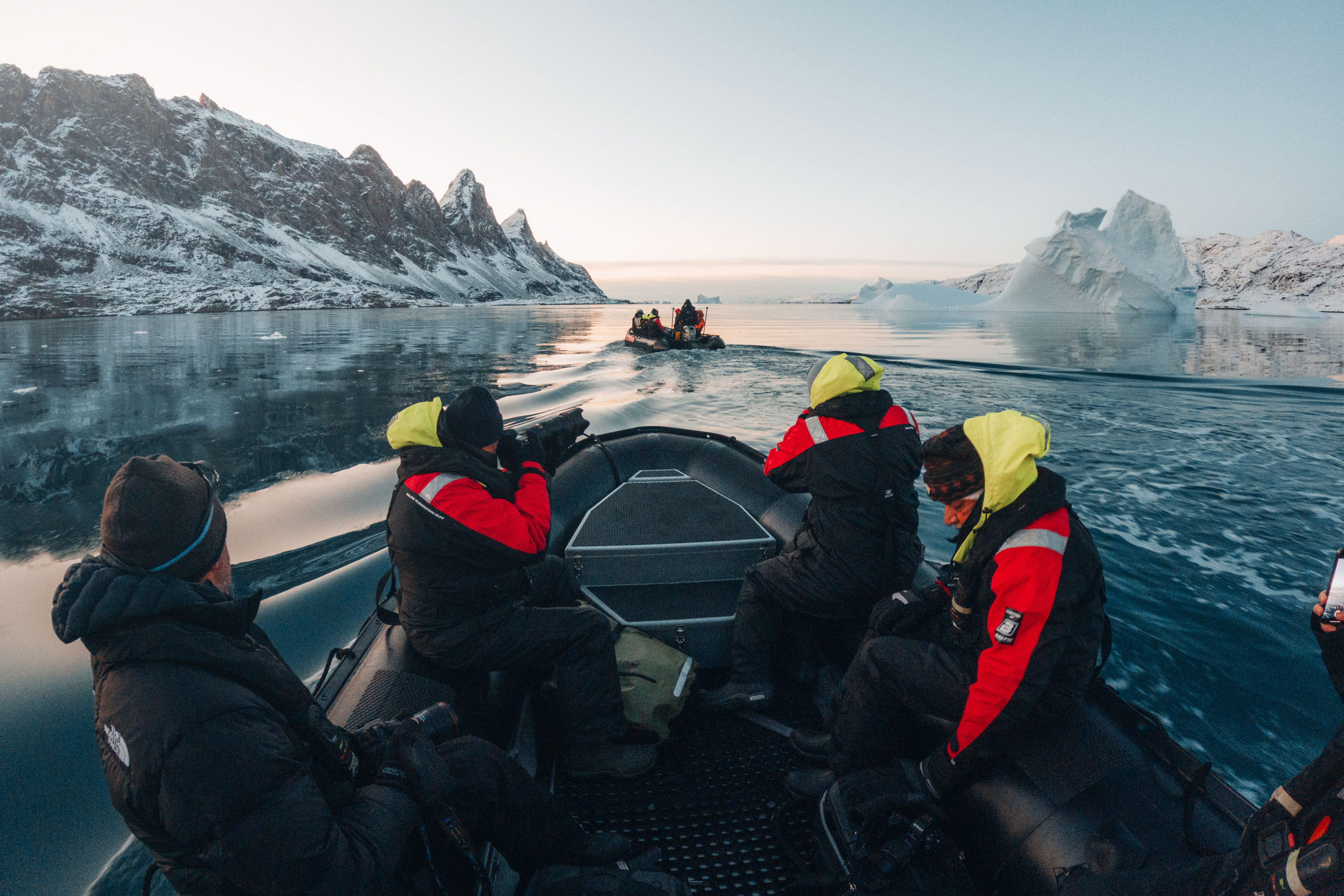 people on a boat in Greenland. Iceberg sunset. Zodiac cruise Secret Atlas